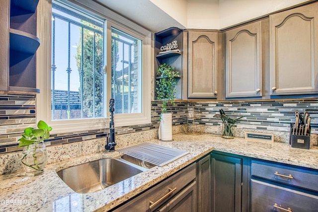 350 Thunderbird Dr Unit 59, El Paso, TX 79912 - kitchen with open shelves, decorative backsplash, and light stone counters