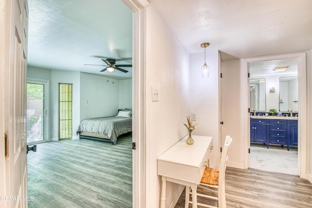 350 Thunderbird Dr Unit 59, El Paso, TX 79912 - bedroom with light wood-type flooring, ensuite bathroom, access to outside, and a textured ceiling