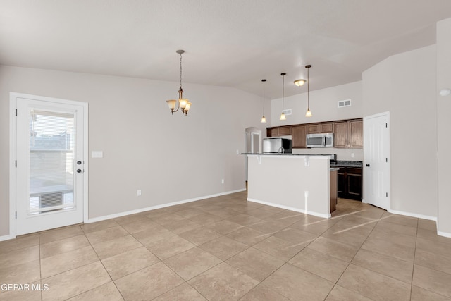 14197 Ranier Point Dr, El Paso, TX 79938 - kitchen with fridge, stainless steel microwave, light tile patterned floors, hanging light fixtures, and a chandelier