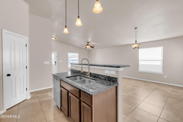 14197 Ranier Point Dr, El Paso, TX 79938 - kitchen with dishwasher, light tile patterned floors, ceiling fan, a center island with sink, and dark stone counters