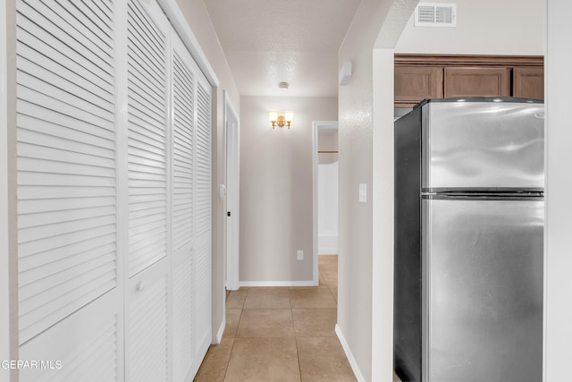 14197 Ranier Point Dr, El Paso, TX 79938 - hallway with light tile patterned floors and a textured ceiling