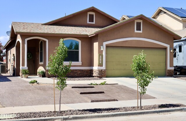 14251 Rattler Point Dr, El Paso, TX 79938 - view of front facade with stucco siding, driveway, stone siding, a garage, and roof with shingles