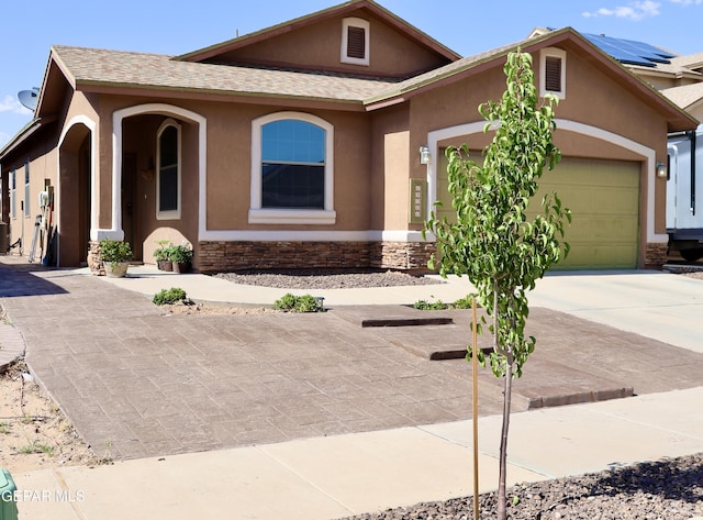 14251 Rattler Point Dr, El Paso, TX 79938 - view of front facade with stucco siding, stone siding, an attached garage, driveway, and roof with shingles