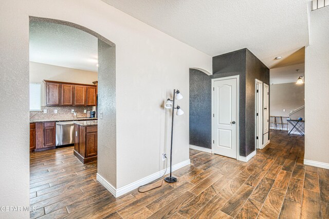 401 Everlook Ln, Horizon City, TX 79928 - corridor featuring arched walkways, dark wood finished floors, and a textured ceiling