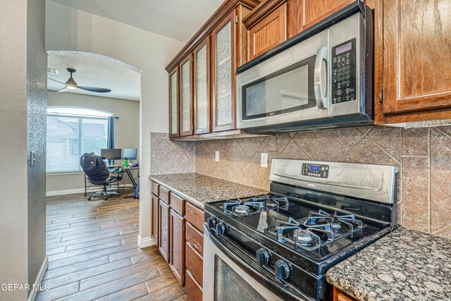 401 Everlook Ln, Horizon City, TX 79928 - kitchen with stainless steel appliances, brown cabinets, a ceiling fan, and a desk