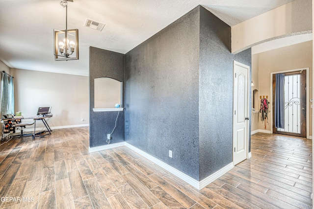 401 Everlook Ln, Horizon City, TX 79928 - spare room with wood finish floors, a chandelier, an office area, and plenty of natural light