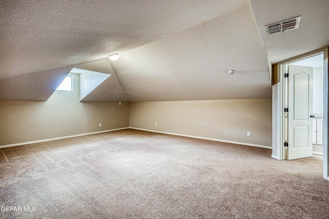 401 Everlook Ln, Horizon City, TX 79928 - additional living space featuring carpet floors, a textured ceiling, and vaulted ceiling