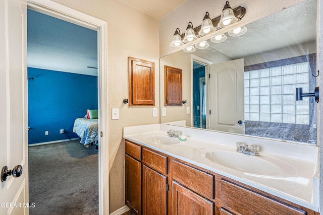 401 Everlook Ln, Horizon City, TX 79928 - bathroom featuring ensuite bath, double vanity, and a textured wall