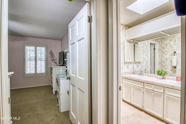 5430 Davis Cup Ct, El Paso, TX 79932 - kitchen with a skylight, light colored carpet, and tile countertops