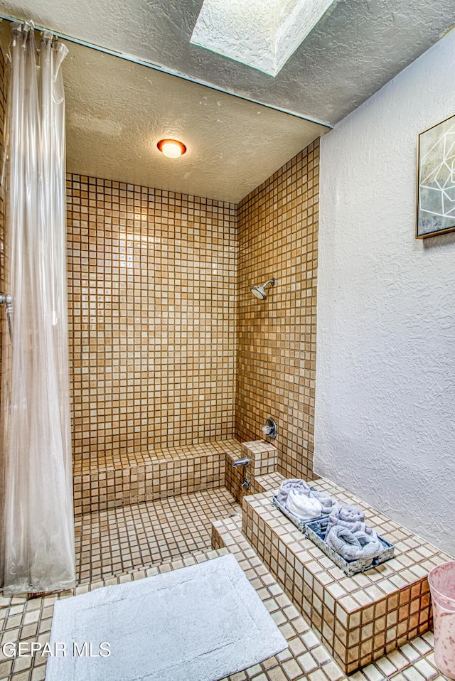 5430 Davis Cup Ct, El Paso, TX 79932 - full bathroom featuring a textured wall, a textured ceiling, a tile shower, and tile patterned floors