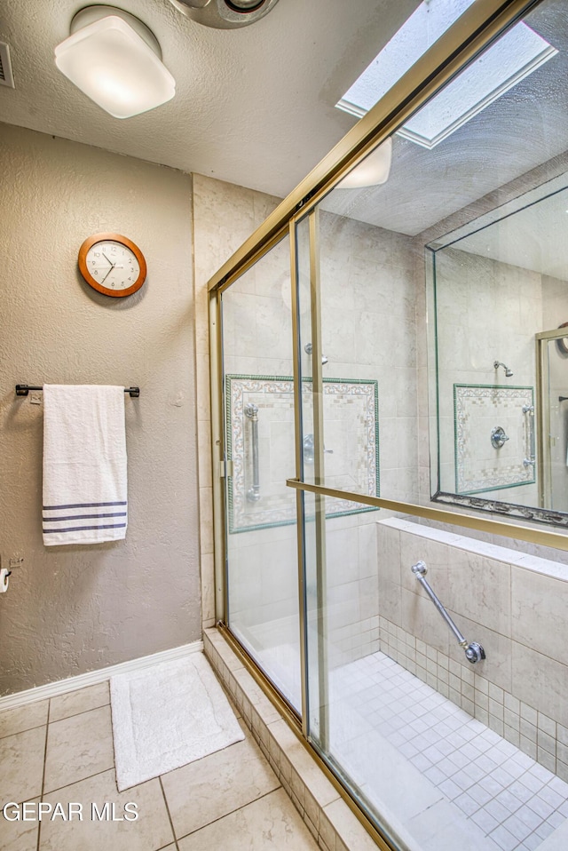 5430 Davis Cup Ct, El Paso, TX 79932 - full bathroom with a stall shower, tile patterned floors, a textured ceiling, a skylight, and a textured wall