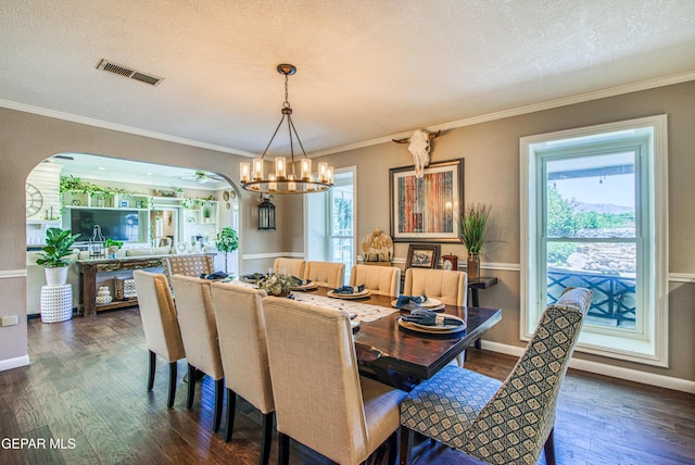5430 Davis Cup Ct, El Paso, TX 79932 - dining room featuring a chandelier, dark wood-type flooring, arched walkways, ornamental molding, and a textured ceiling
