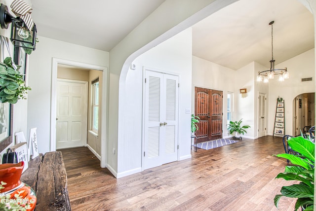 5430 Davis Cup Ct, El Paso, TX 79932 - entrance foyer with arched walkways, a chandelier, wood finished floors, and high vaulted ceiling