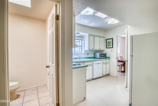 5430 Davis Cup Ct, El Paso, TX 79932 - kitchen featuring white appliances, a skylight, light countertops, and light flooring