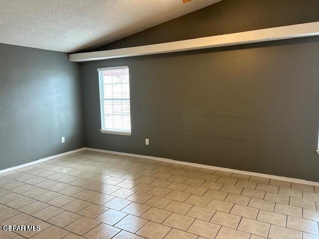 9728 El Tepeyac Ave, El Paso, TX 79927 - unfurnished room with vaulted ceiling, a textured ceiling, and light tile patterned flooring