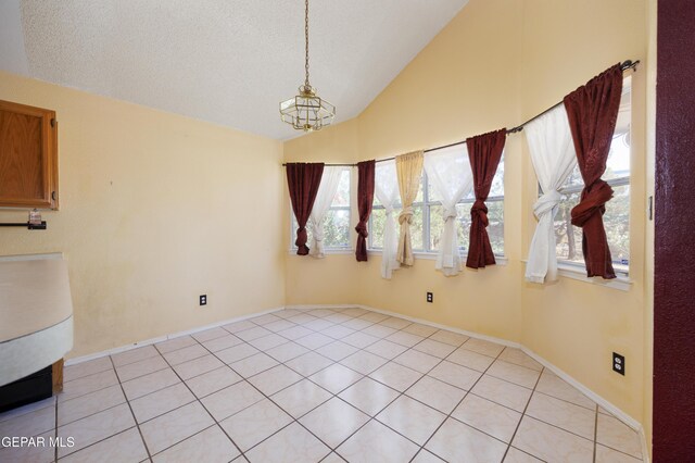11969 Oak Abbey Ct, El Paso, TX 79936 - unfurnished dining area with lofted ceiling, a chandelier, light tile patterned floors, and a textured ceiling