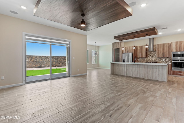 14904 John Mcneely Ave, El Paso, TX 79938 - kitchen with appliances with stainless steel finishes, wall chimney exhaust hood, modern cabinets, light countertops, and decorative backsplash