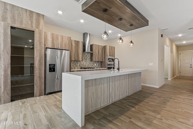 14904 John Mcneely Ave, El Paso, TX 79938 - kitchen with stainless steel appliances, wall chimney exhaust hood, light wood-style flooring, modern cabinets, and light countertops