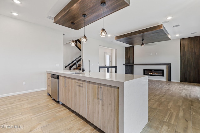 14904 John Mcneely Ave, El Paso, TX 79938 - kitchen with stainless steel dishwasher, modern cabinets, light brown cabinetry, light wood-style floors, and pendant lighting