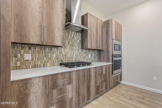 14904 John Mcneely Ave, El Paso, TX 79938 - kitchen featuring appliances with stainless steel finishes, range hood, backsplash, and light wood-style floors