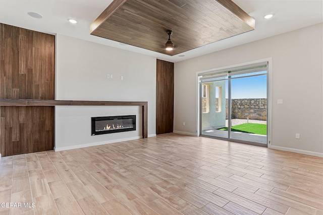 14904 John Mcneely Ave, El Paso, TX 79938 - unfurnished living room with light wood-type flooring, a glass covered fireplace, recessed lighting, and wooden ceiling