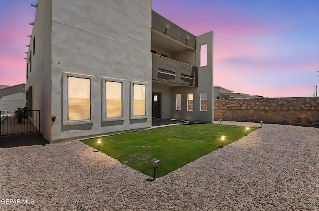 14904 John Mcneely Ave, El Paso, TX 79938 - back of property at dusk featuring a balcony, a patio, and stucco siding