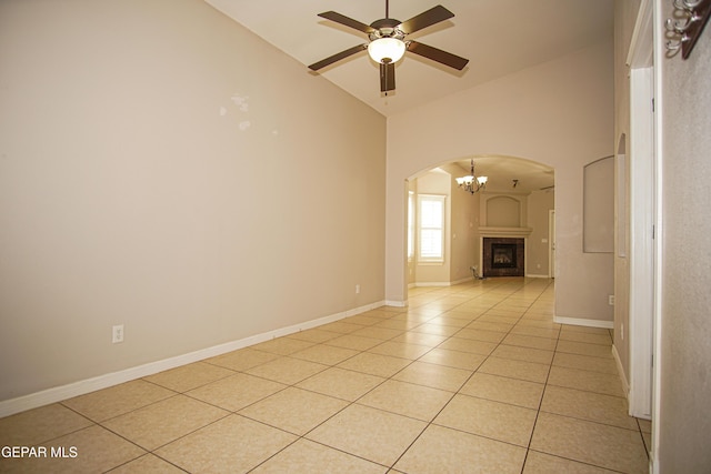 5353 Manuel Puentes Ct, El Paso, TX 79934 - spare room featuring arched walkways, a ceiling fan, light tile patterned floors, high vaulted ceiling, and a chandelier