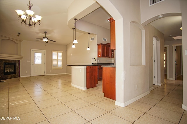 5353 Manuel Puentes Ct, El Paso, TX 79934 - kitchen featuring open floor plan, ceiling fan, light tile patterned floors, a high end fireplace, and dark brown cabinets