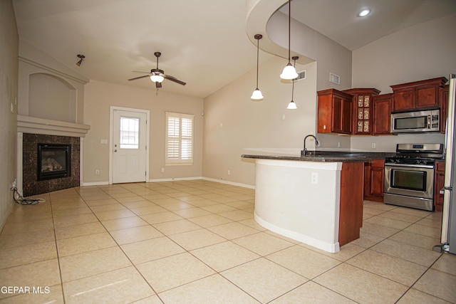 5353 Manuel Puentes Ct, El Paso, TX 79934 - kitchen featuring stainless steel appliances, dark countertops, open floor plan, a ceiling fan, and light tile patterned floors