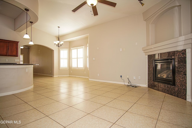 5353 Manuel Puentes Ct, El Paso, TX 79934 - unfurnished living room featuring light tile patterned floors, a fireplace, ceiling fan, and a chandelier