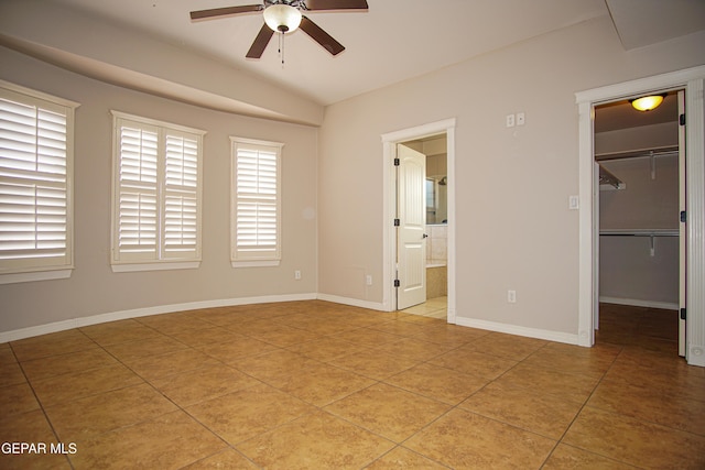 5353 Manuel Puentes Ct, El Paso, TX 79934 - unfurnished bedroom with light tile patterned floors, a walk in closet, multiple windows, lofted ceiling, and connected bathroom