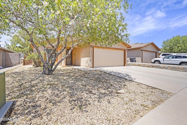 14215 Otter Point Ct, El Paso, TX 79938 - view of property hidden behind natural elements with stucco siding, an attached garage, and driveway