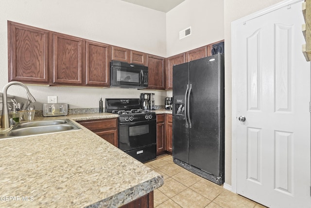 14215 Otter Point Ct, El Paso, TX 79938 - kitchen with black appliances, light tile patterned flooring, and light countertops