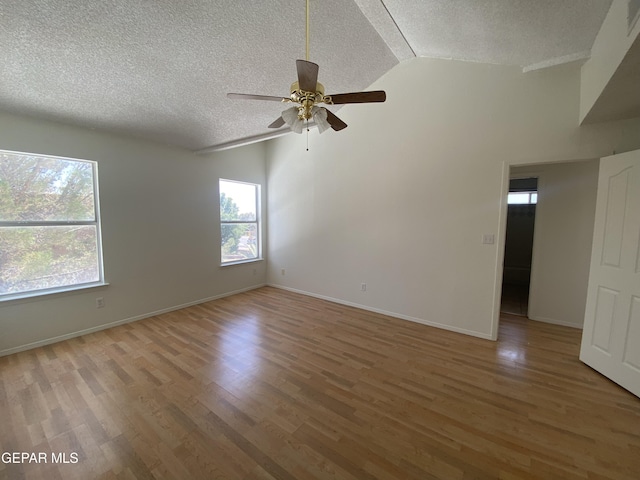 1409 Rainbow Ridge Dr, El Paso, TX 79912 - spare room with a textured ceiling, vaulted ceiling, a ceiling fan, and light wood-type flooring