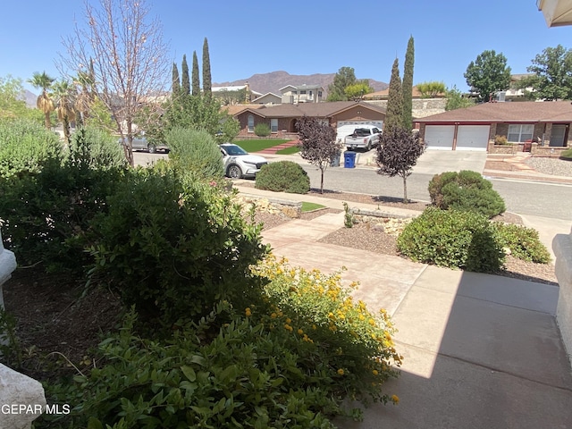1409 Rainbow Ridge Dr, El Paso, TX 79912 - view of yard featuring driveway, a residential view, an attached garage, and a mountain view