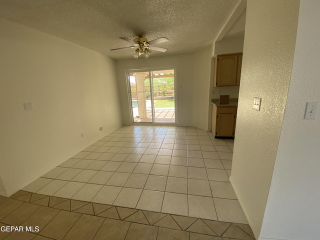 1409 Rainbow Ridge Dr, El Paso, TX 79912 - spare room with ceiling fan, a textured ceiling, light tile patterned flooring, and a textured wall