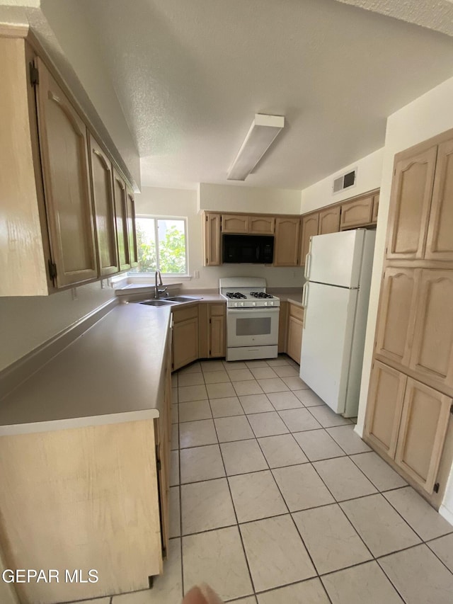 1409 Rainbow Ridge Dr, El Paso, TX 79912 - kitchen featuring white appliances, light tile patterned floors, light brown cabinets, light countertops, and a textured ceiling