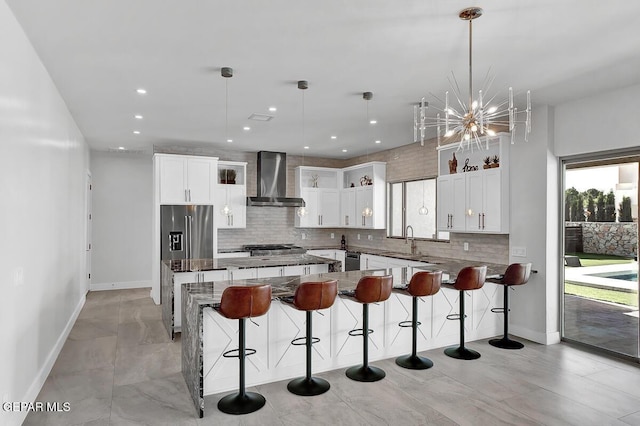 525 Cotton Blossom Ave, El Paso, TX 79922 - kitchen with wall chimney range hood, decorative backsplash, a kitchen bar, white cabinetry, and recessed lighting