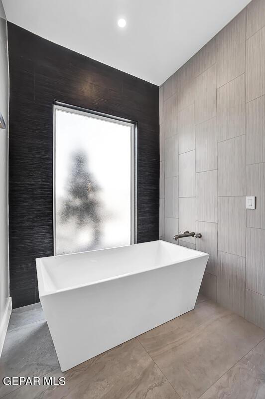 525 Cotton Blossom Ave, El Paso, TX 79922 - full bathroom featuring tile walls and a freestanding tub