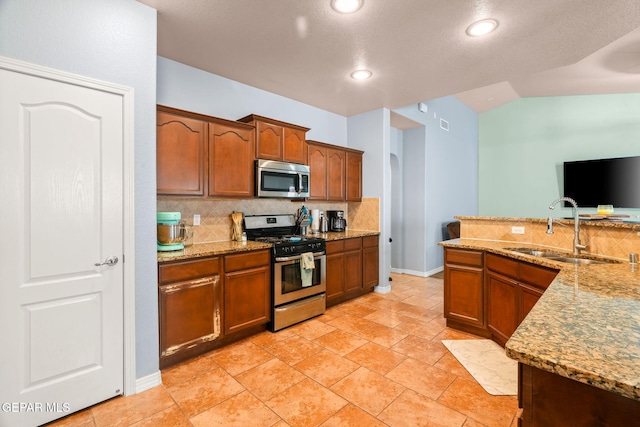 14605 Spanish Point Dr, El Paso, TX 79938 - kitchen with stainless steel appliances, tasteful backsplash, light stone counters, recessed lighting, and lofted ceiling