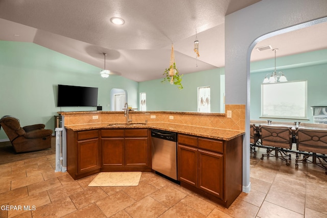 14605 Spanish Point Dr, El Paso, TX 79938 - kitchen with dishwasher, lofted ceiling, open floor plan, brown cabinetry, and arched walkways