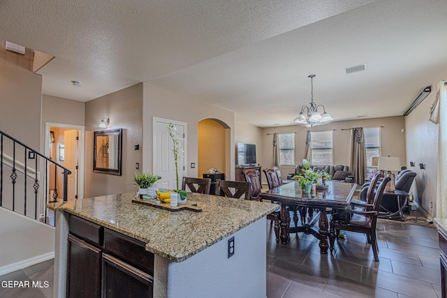 12355 Joe Gomez, El Paso, TX 79928 - kitchen with arched walkways, open floor plan, light stone countertops, decorative light fixtures, and a chandelier
