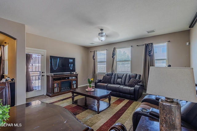 12355 Joe Gomez, El Paso, TX 79928 - living room with a textured ceiling, arched walkways, ceiling fan, and carpet
