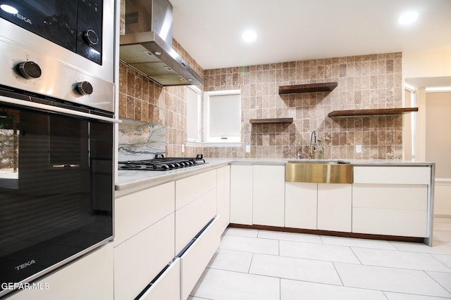 1465 Fito Hernandez St, El Paso, TX 79928 - kitchen with wall chimney range hood, appliances with stainless steel finishes, open shelves, decorative backsplash, and light countertops