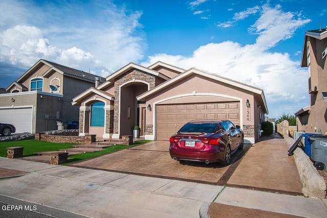11344 Acoma St, El Paso, TX 79934 - view of front of home featuring stone siding, concrete driveway, a garage, and stucco siding