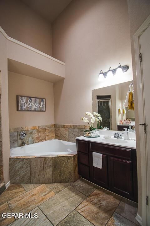 11344 Acoma St, El Paso, TX 79934 - full bathroom featuring a garden tub, vanity, and stone finish flooring