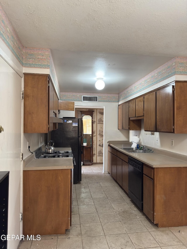 3376 Guthrie St, El Paso, TX 79935 - kitchen with dishwasher, light countertops, a textured ceiling, and under cabinet range hood