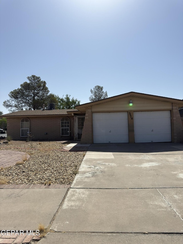 3376 Guthrie St, El Paso, TX 79935 - ranch-style house featuring brick siding, concrete driveway, and a garage