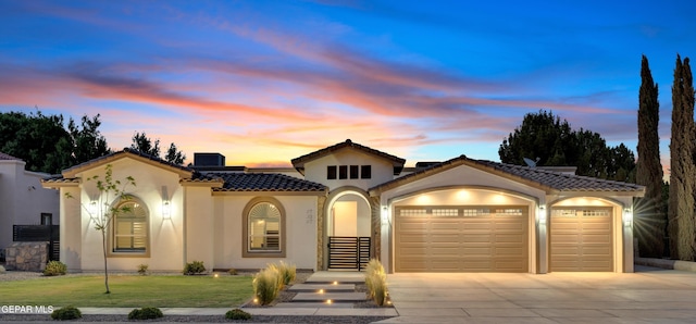 737 Al Smith Ln, El Paso, TX 79932 - mediterranean / spanish house featuring a garage, stucco siding, concrete driveway, a tiled roof, and a front lawn