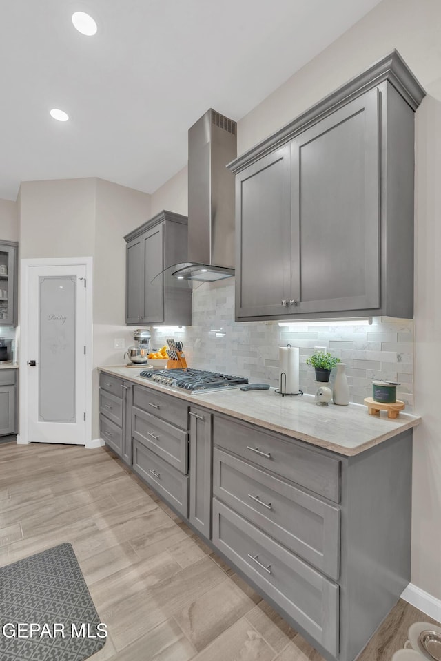 737 Al Smith Ln, El Paso, TX 79932 - kitchen with gray cabinets, wall chimney exhaust hood, stainless steel gas cooktop, decorative backsplash, and recessed lighting